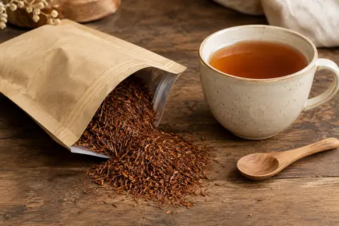 Sachet refermable de rooibos en vrac présenté près d’une tasse d’infusion ambrée