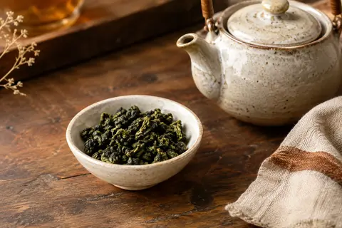 Feuilles vert émeraude de thé oolong de Dalat présentées dans une coupelle en céramique