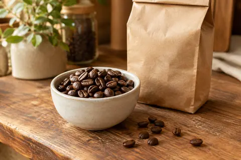 Grains de café brun moyen dans un bol en céramique crème sur un comptoir en bois patiné