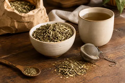 Yerba maté Playadito en feuilles en vrac, présentée dans un bol en céramique sur un comptoir en bois.